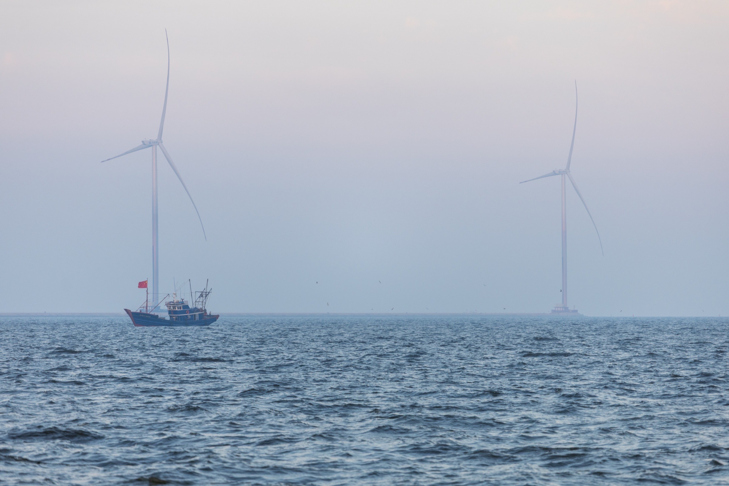 滨海海面、渔船与海上风机